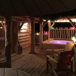 la terrasse de nuit de la cabane avec le spa