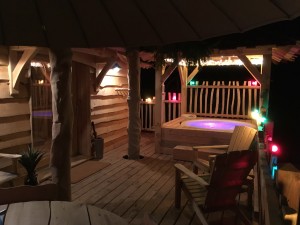 la terrasse de nuit de la cabane avec le spa