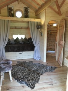 le lit double en alcôve de la cabane avec le spa